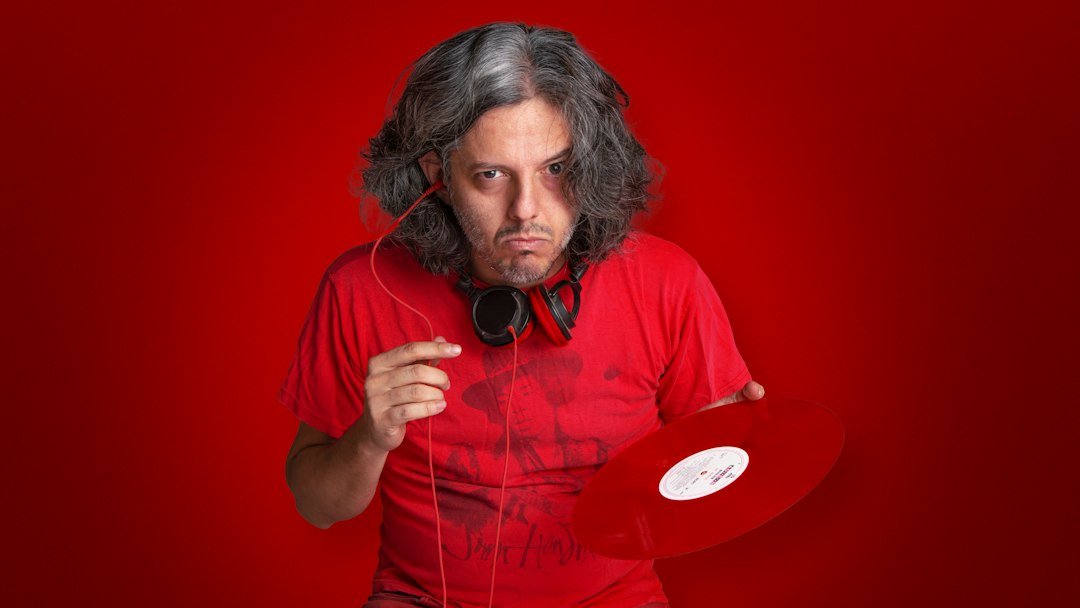 man in red crew neck t-shirt wearing black headphones