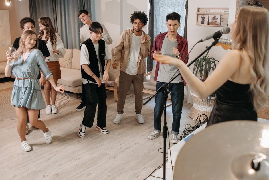 A lively home party featuring diverse group dancing and enjoying live music.