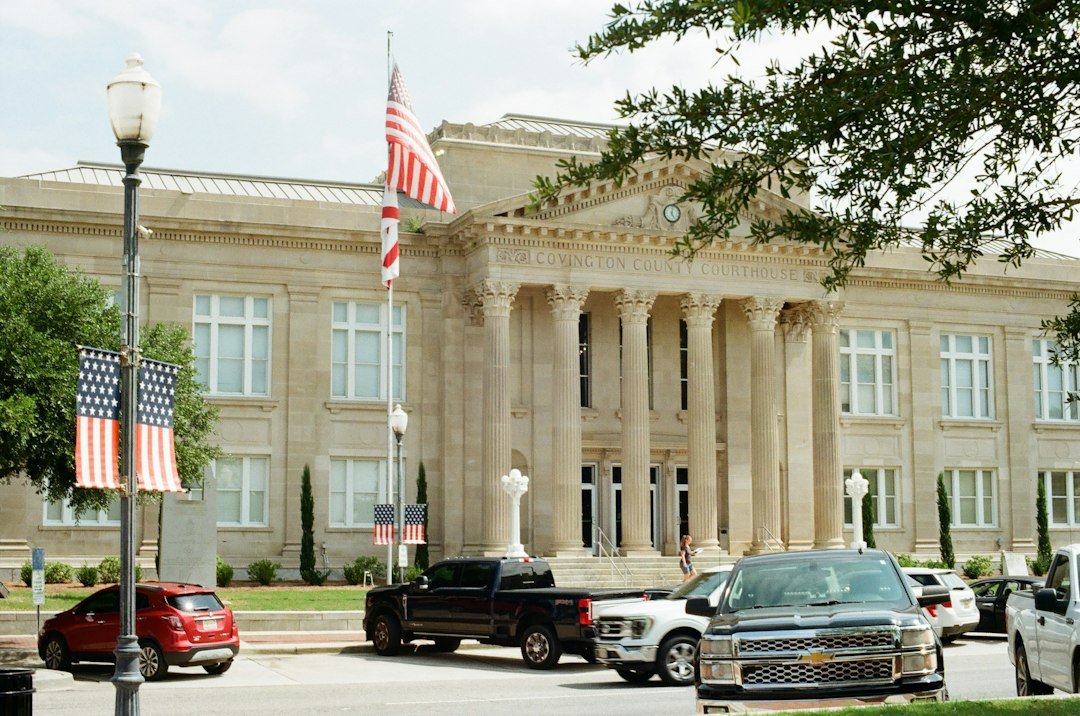 Classical building with columns, american flags, and parked cars